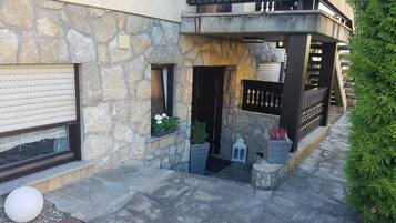 Un edificio in pietra con un balcone, una finestra con una pianta e un lampione.