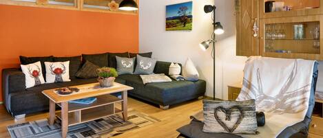 Una sala de estar acogedora con un sofá, una mesa de centro y un sillón.