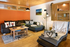 Un salon confortable avec un canapé, une table basse et un fauteuil.