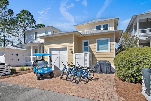 A two-story house with a garage, a covered patio, and a bicycle rack.
