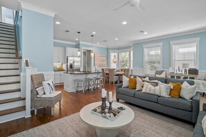 Ein modernes Wohnzimmer mit grauem Sofa, einem Couchtisch und einer Treppe.
