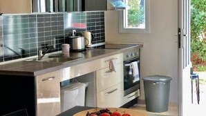 Une cuisine moderne dotée d’un îlot central, d’appareils électroménagers en acier inoxydable et d’une grande fenêtre.