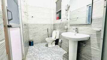 A bathroom with a toilet, sink, and mirror.