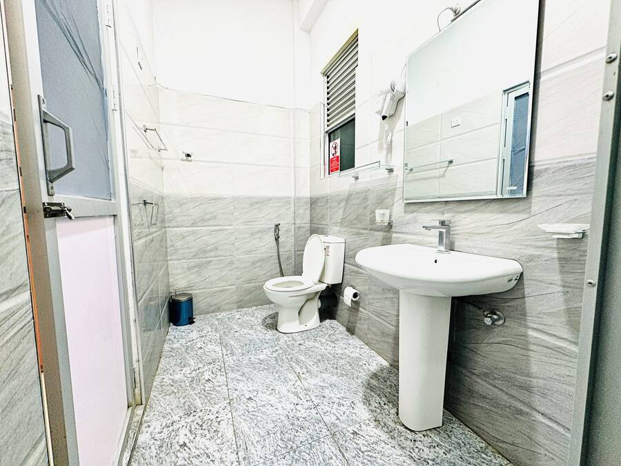 A bathroom with a toilet, sink, and mirror.