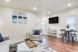 A modern living room with a grey sofa, a grey armchair, a coffee table, and a TV mounted on the wall. - Dog-Friendly Sheboygan Home - 1 Mi to Town! (Sheboygan)