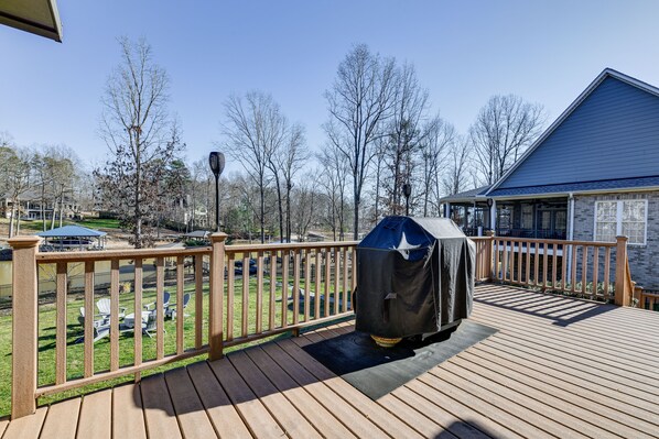 A wooden deck with a barbecue grill, a covered seating area, and a view of a backyard with a lawn and trees. - Waterfront Lake Norman Retreat w/ Dock + Hot Tub! (Terrell)