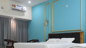 Ein Schlafzimmer mit einem hölzernen Bett, einem Sessel, einem Schreibtisch und einer Wandklimaanlage.