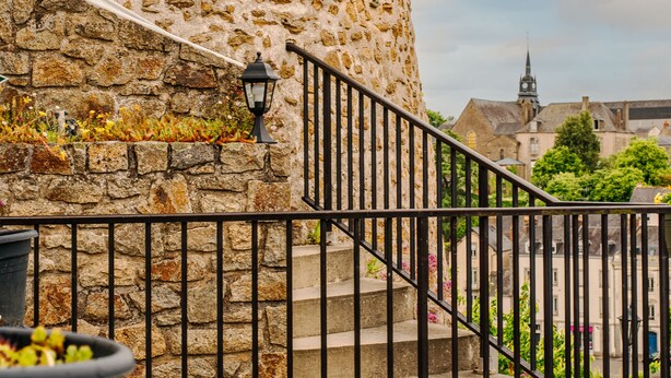 A stone building with a spiral staircase and a metal railing. - Hôtel la Tour des Anglais (Mayenne)