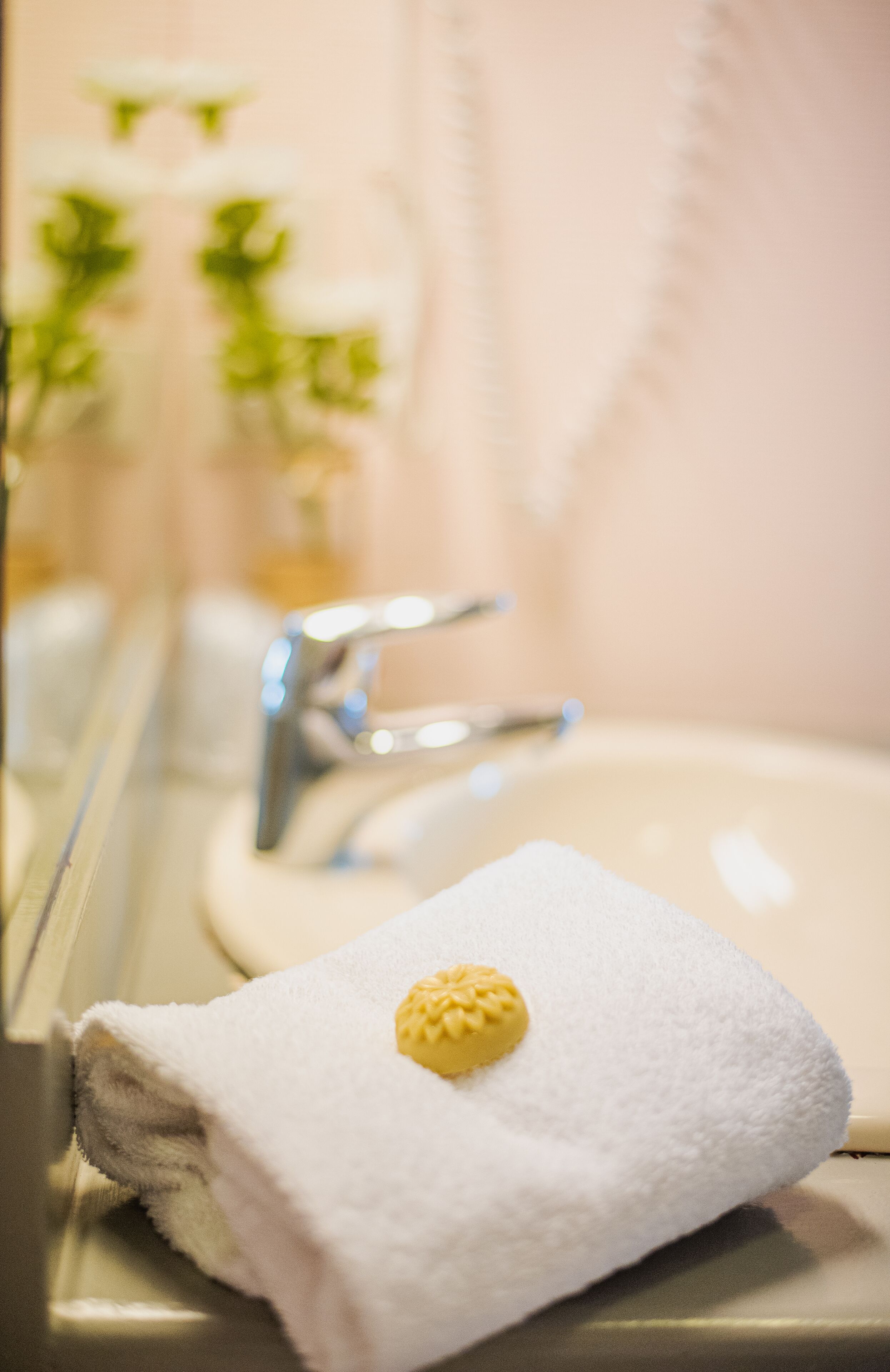A bathroom with a sink, mirror, and a towel with a yellow object on it.