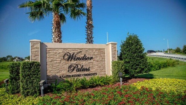A sign for Windsor Palms, a resort community, with a landscaped garden and palm trees. - Sunshine 3bdrm pool house near Disney (Kissimmee)