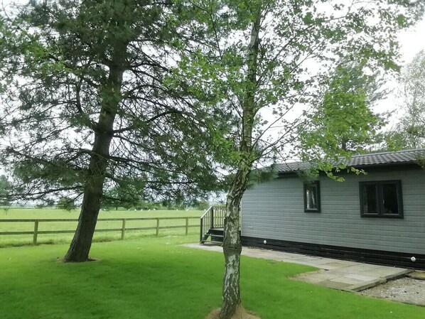 A cabin with a wooden deck and a staircase leading to a porch.