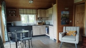 Un intérieur de chalet chaleureux comprenant un coin repas, une cuisine et un espace salon confortable.