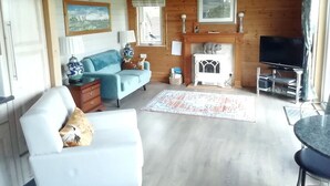 Un salon chaleureux avec une cheminée, un canapé, un téléviseur et un coin repas.