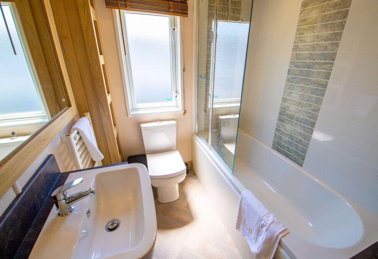 Een moderne badkamer met een ruime ligbad, een apart toilet en een wastafel.