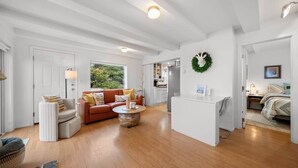 A spacious living area with a sofa, coffee table, and a kitchen in the background. - #StayInMyDistrict SurfsideHaven (Rockaway Beach)