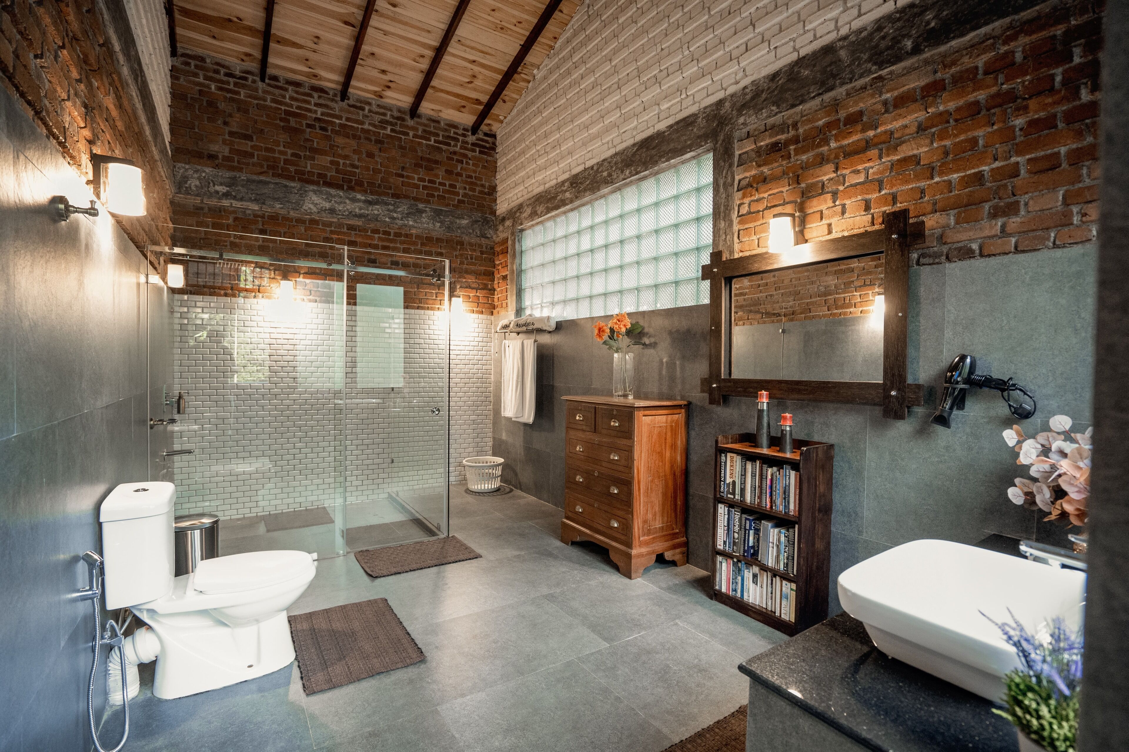 A modern bathroom with a glass shower, a wooden vanity, and a large mirror.