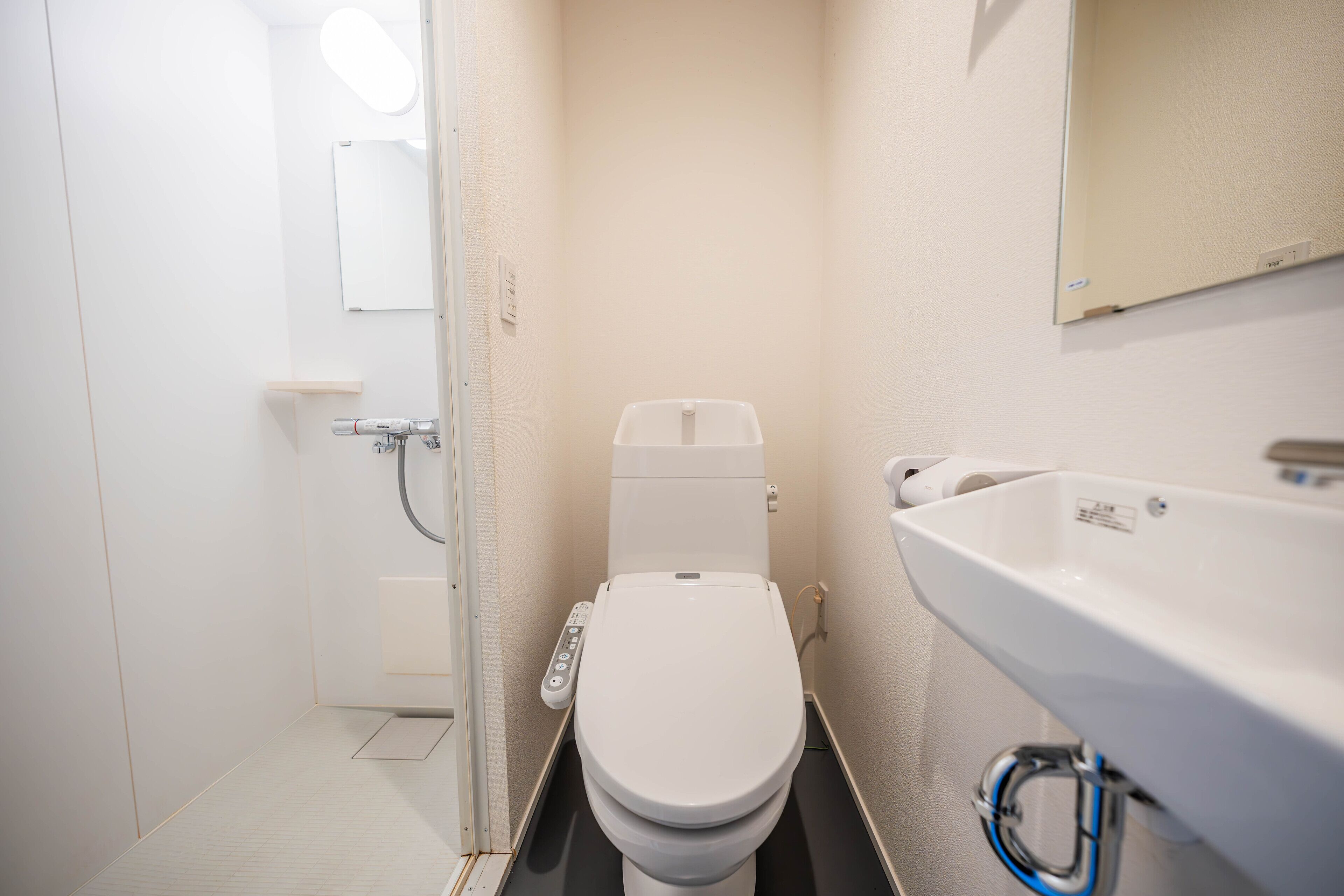 Une petite salle de bain moderne, équipée de toilettes, d’un lavabo et d’un miroir.