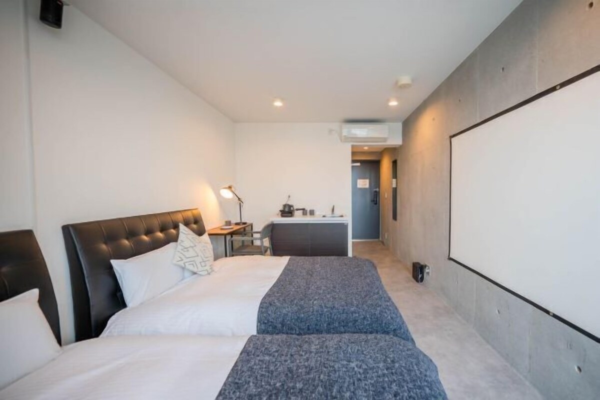 A modern hotel room with a large bed, a desk, and a seating area.