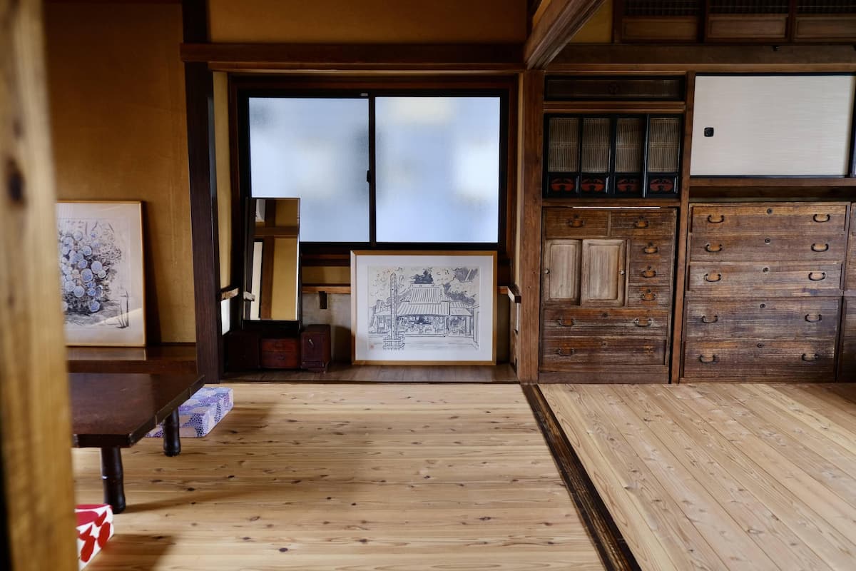 Um quarto japonês tradicional com pisos de tatame, portas deslizantes e armários de madeira.