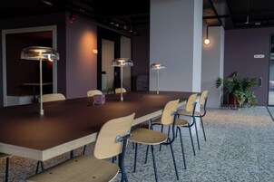 Ein Konferenzraum mit einem langen Tisch, sechs Stühlen und drei Pendelleuchten.
