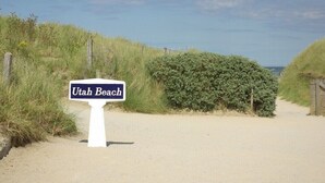 A sign reading "Utah Beach" in a natural setting with sand and vegetation. - 2-room garage facing with panoramic view of the sea and TATIHOU island (UNESCO) (Saint-Vaast-la-Hougue)