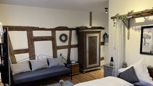 A bedroom with a bed, a sofa bed, a wardrobe, and a small table. - Der Moserhof (Oberaurach)