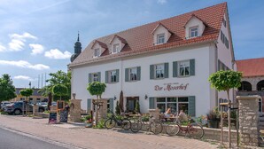 A two-story building with a red-tiled roof and green shutters, labeled "Der Moscherhof." - Der Moserhof (Oberaurach)