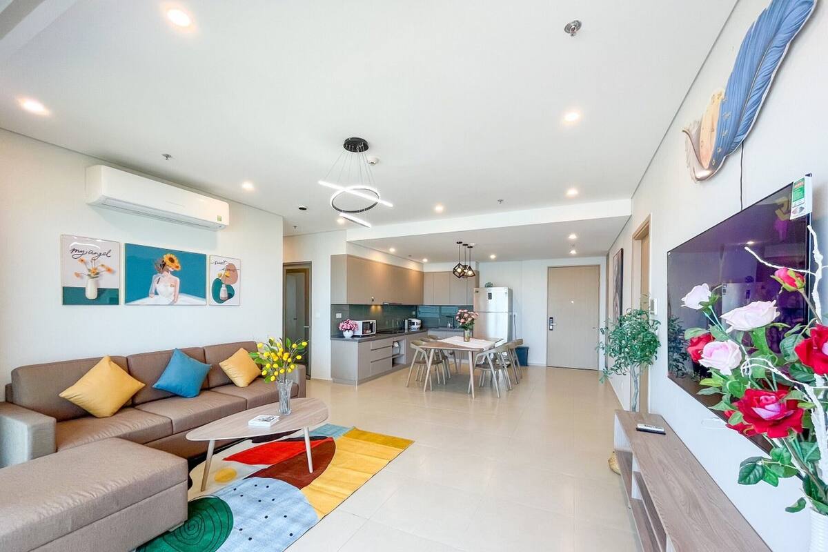 Una sala de estar moderna con un sofá, una mesa de centro y un comedor con una mesa y sillas.