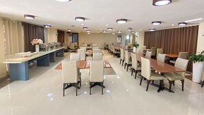 A spacious dining area with multiple tables and chairs, a buffet counter, and ceiling lights. - Arzo Hotel Manila (Manila)