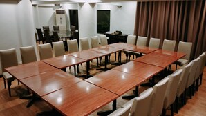 A conference room with a long table and multiple chairs, equipped with a projector and a small table with a computer. - Arzo Hotel Manila (Manila)