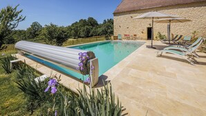 A swimming pool with a stone building in the background.