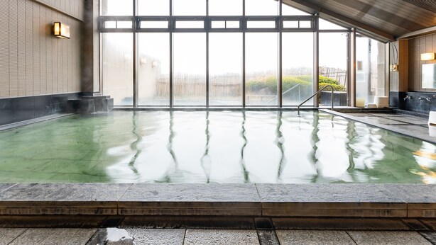 A large indoor swimming pool with clear glass walls, a tiled floor, and a high ceiling with ventilation. - Tabist Healthy Pal Akagi (Shibukawa)