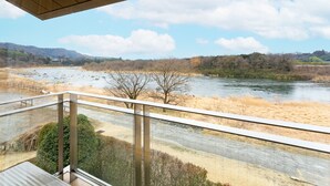 A view from a balcony overlooking a river with a bridge in the foreground and hills in the background. - Tabist Healthy Pal Akagi (Shibukawa)