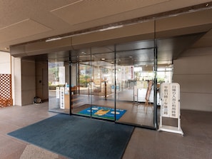 A hotel entrance with a glass door, a blue mat, and a signboard with Japanese text. - Tabist Healthy Pal Akagi (Shibukawa)