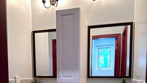 Une salle de bain avec deux lavabos, un miroir et un meuble avec des tiroirs.