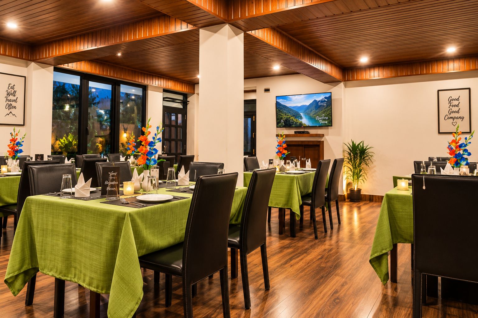 A dining area with tables set for multiple guests, featuring green tablecloths and black chairs.