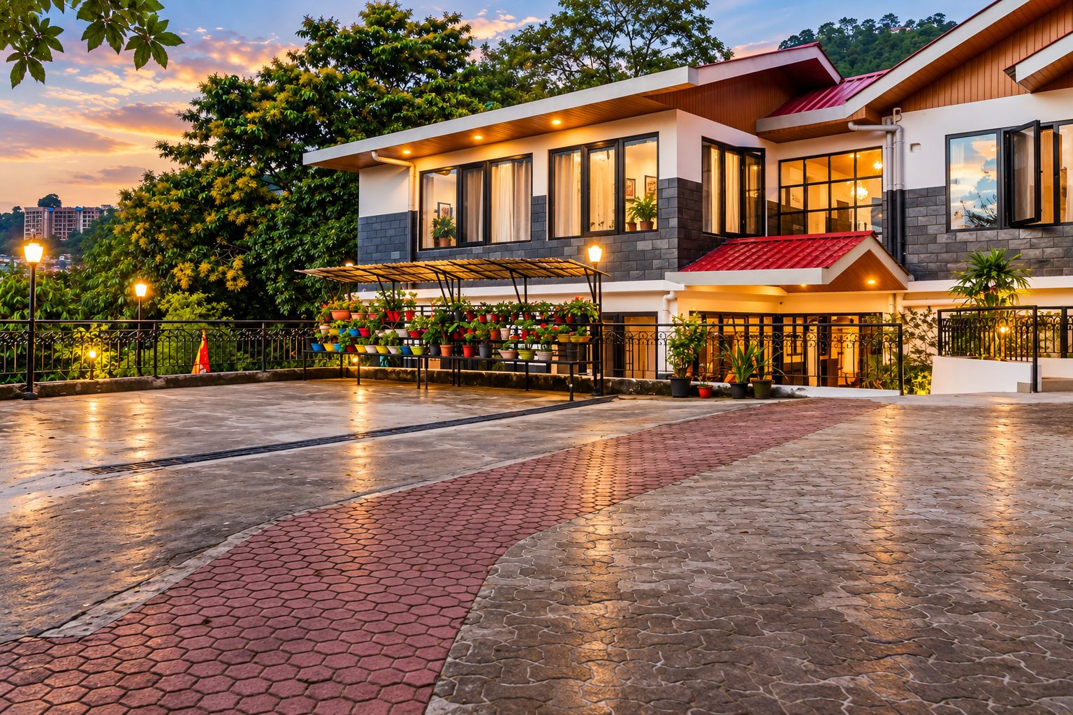 A modern hotel with a spacious courtyard, a covered seating area with potted plants, and a well-lit entrance.