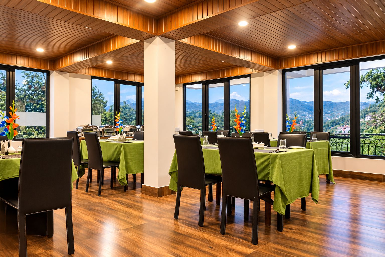A conference room with tables set for a meeting, large windows with a mountain view, and wooden panel ceilings.