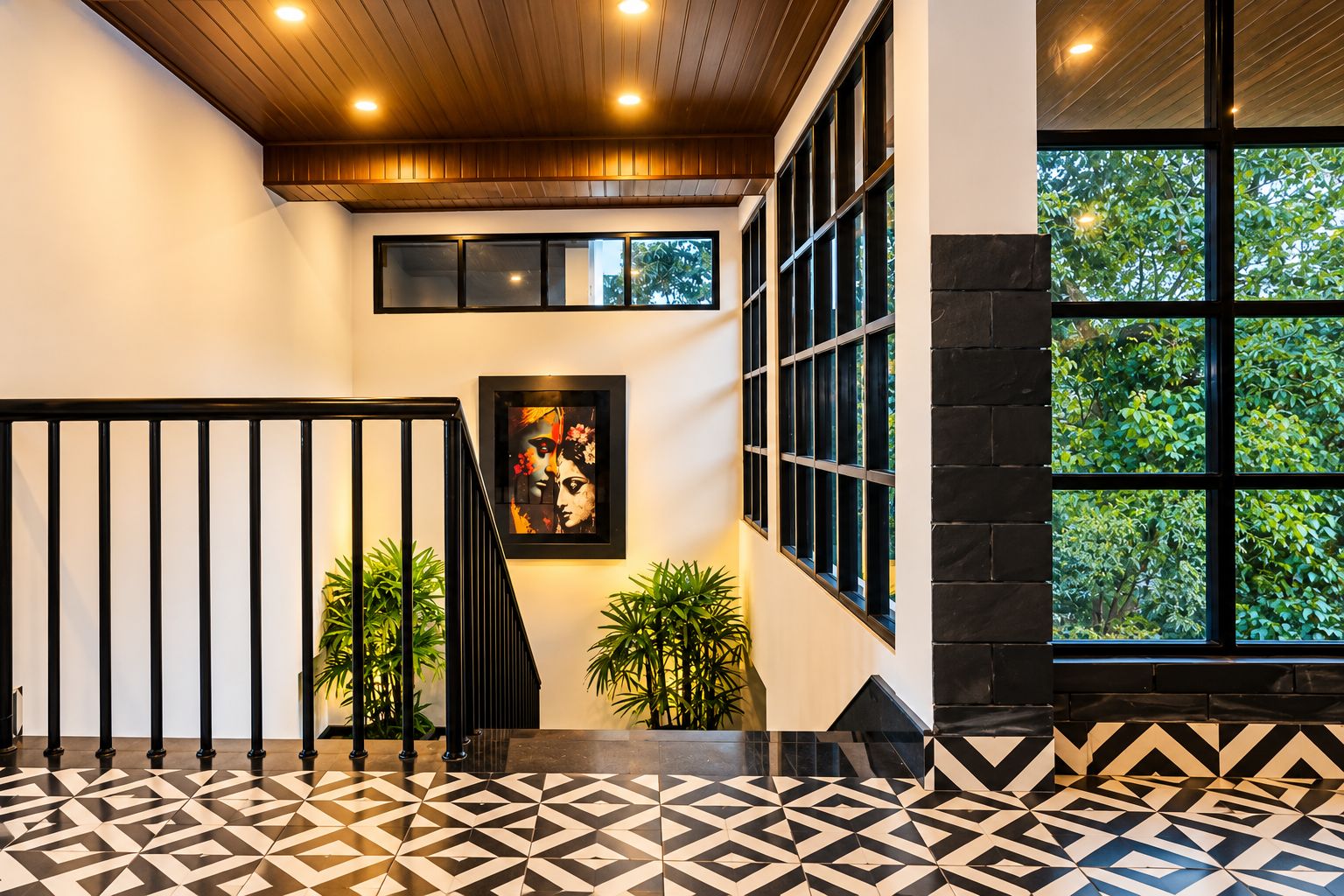 Una escalera con piso de diseño geométrico, barandilla negra y una obra de arte enmarcada en la pared.