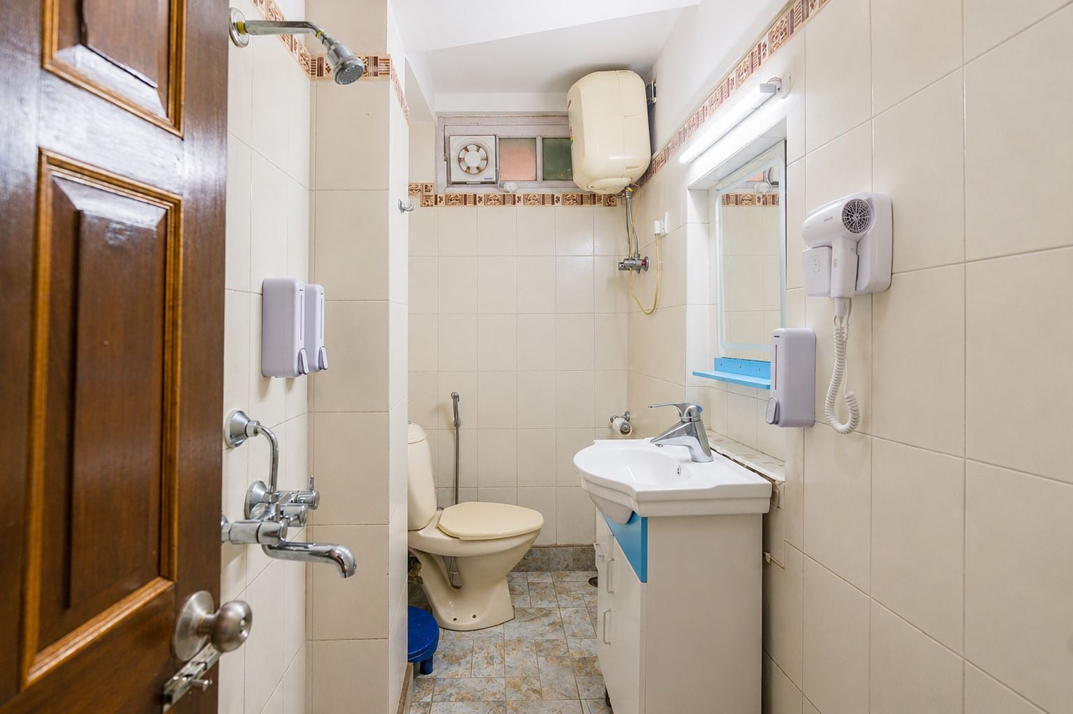 A small bathroom with a toilet, sink, and shower.