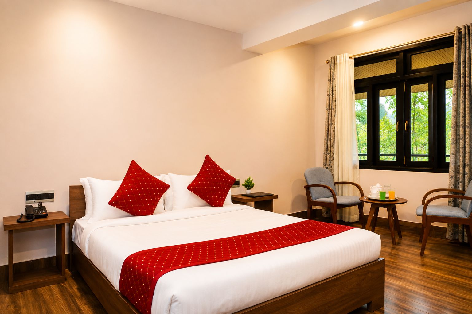 Habitación de hotel con una cama, teléfono en la mesita de noche, una pequeña mesa con tetera y taza, dos sillas y una ventana con cortinas.