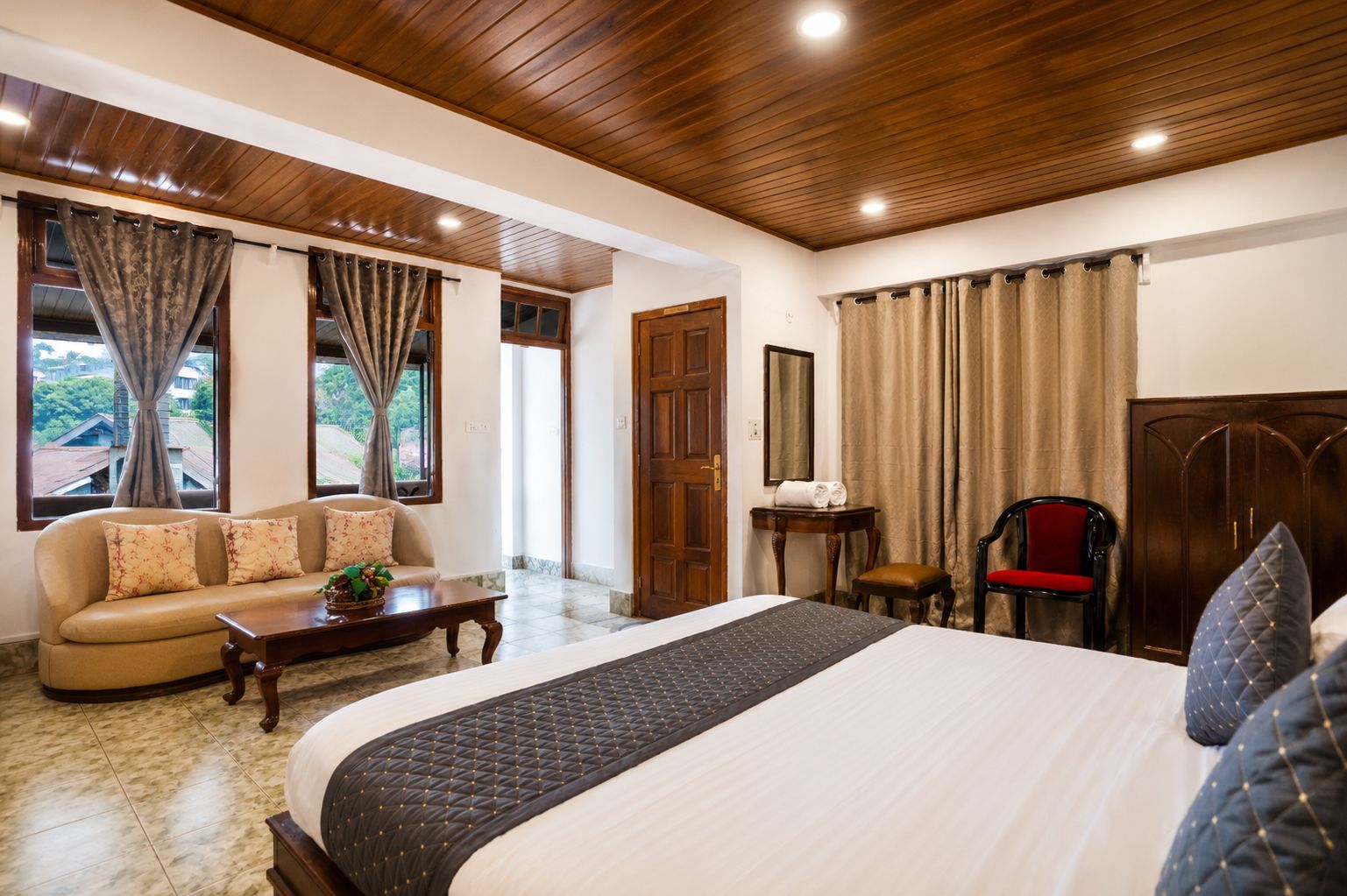 A hotel room with a bed, sofa, and a small table.
