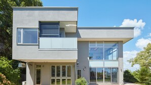 Un edificio moderno de dos pisos con ventanas grandes y techo plano.