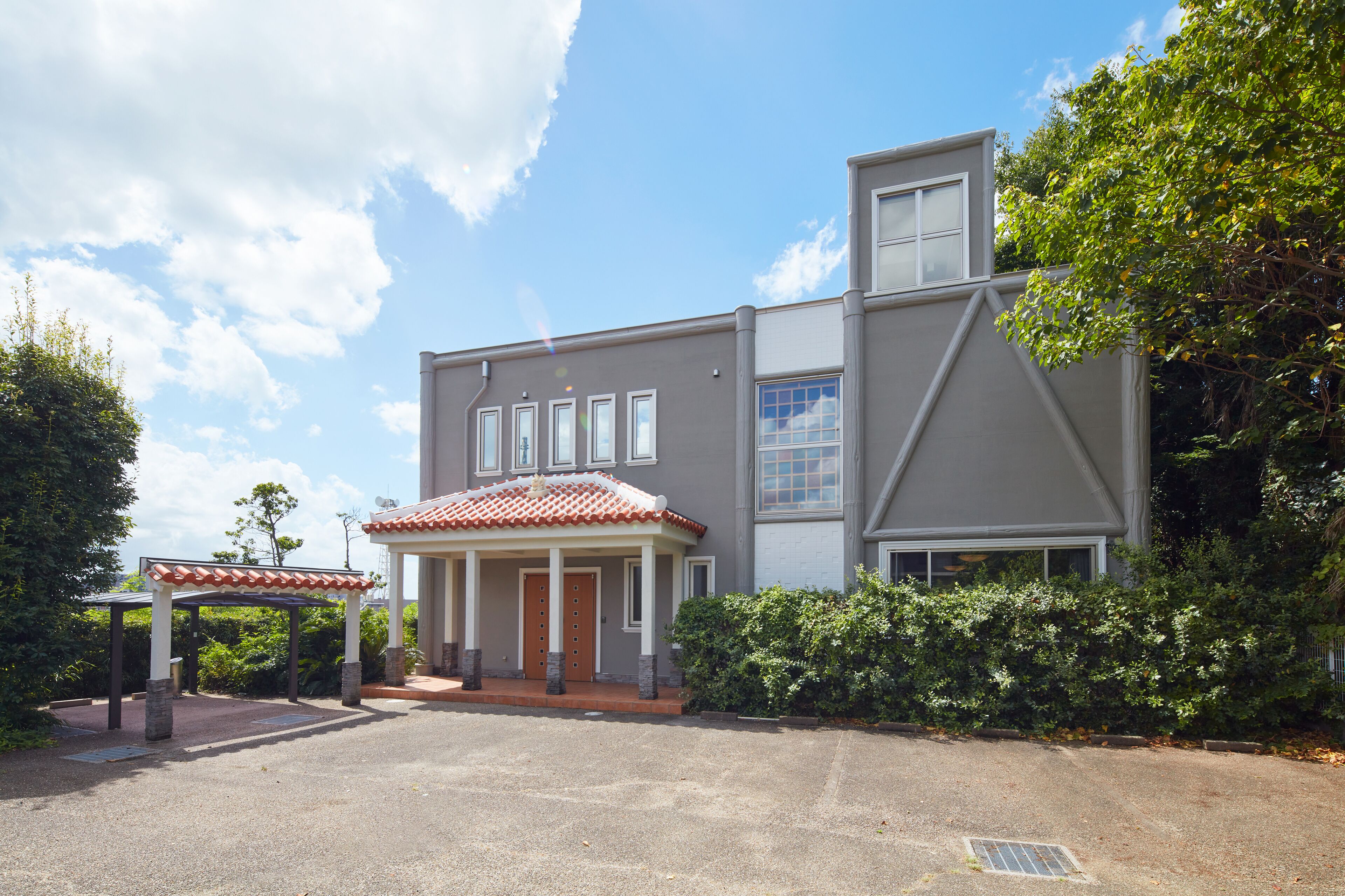 A modern two-story house with a covered porch, a garage, and a well-maintained garden.