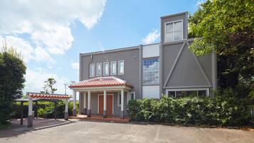 A modern two-story house with a covered porch, a garage, and a well-maintained garden.