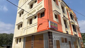 A multi-story building with a sign advertising A/C and non-A/C rooms.