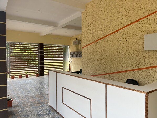Una zona de recepción con suelo estampado, un mostrador de recepción y un cuadro eléctrico en la pared.