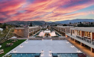 Un hotel con patio central, piscina al aire libre y vistas a la montaña.