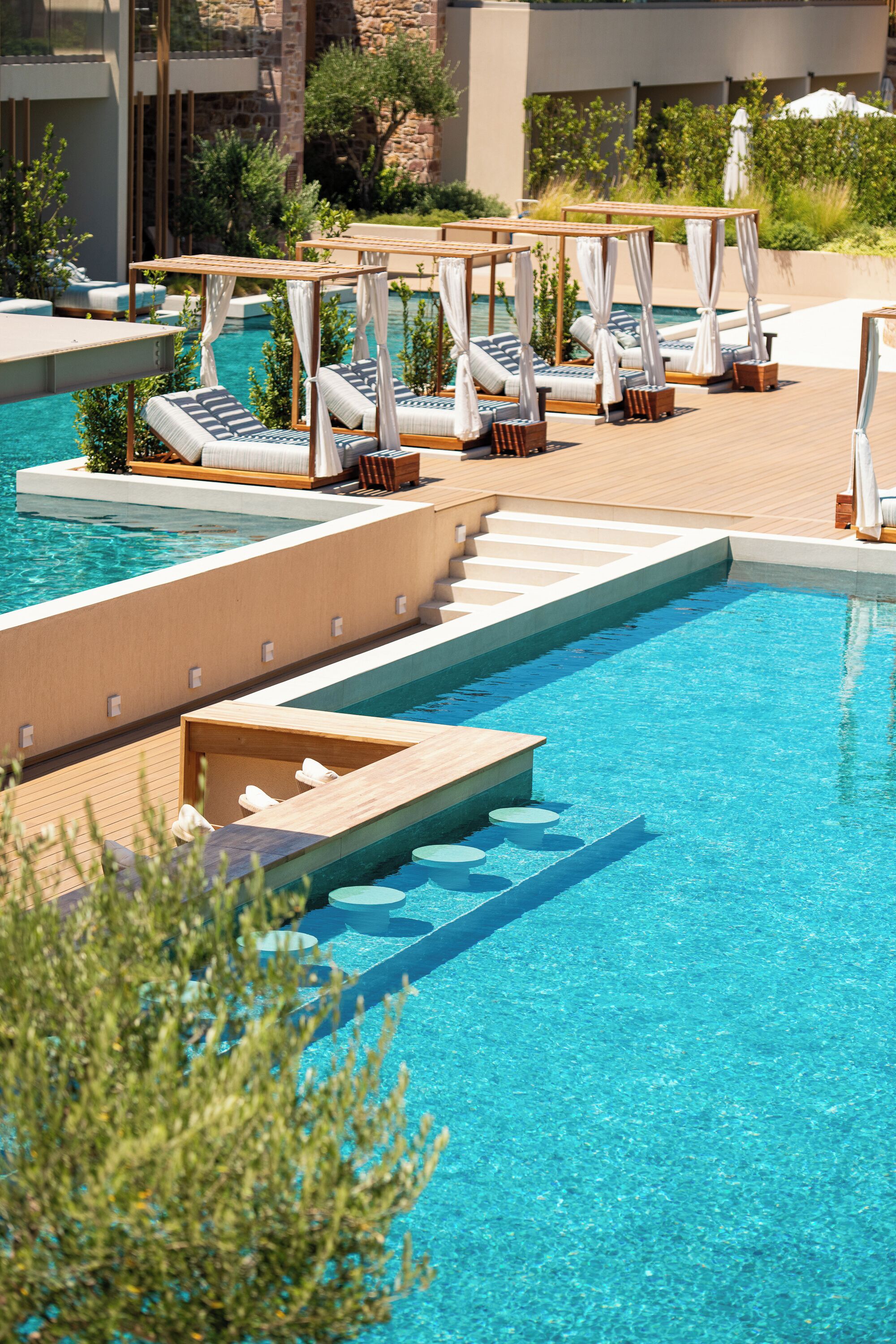 A pool area with multiple sun loungers and a wooden deck.
