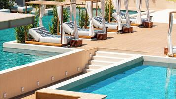 A pool area with multiple sun loungers and a wooden deck.